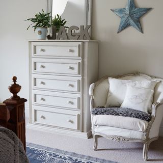 bedroom with storage drawer and armchair