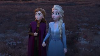 Anna and Elsa hold hands as they look worried in Frozen 2