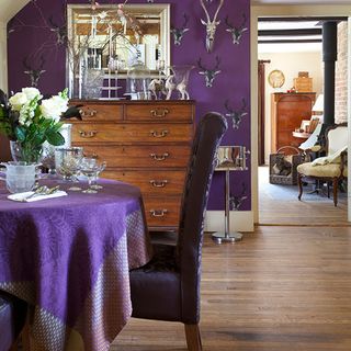 dining room with dining table stag motif wallpaper and bead mirror