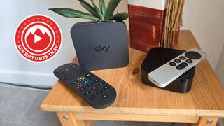 A Sky Stream and an Apple TV 4K sitting side by side on a wooden side table.