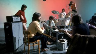 A behind-the-scenes shot of the remastered Let it Be docufilm, one of May's new Disney Plus movies, which shows The Beatles chatting and rehearsing for their final concert in a studio