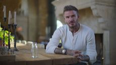 David Beckham sits at a table while being interviewed in Beckham, one of the best Netflix documentaries