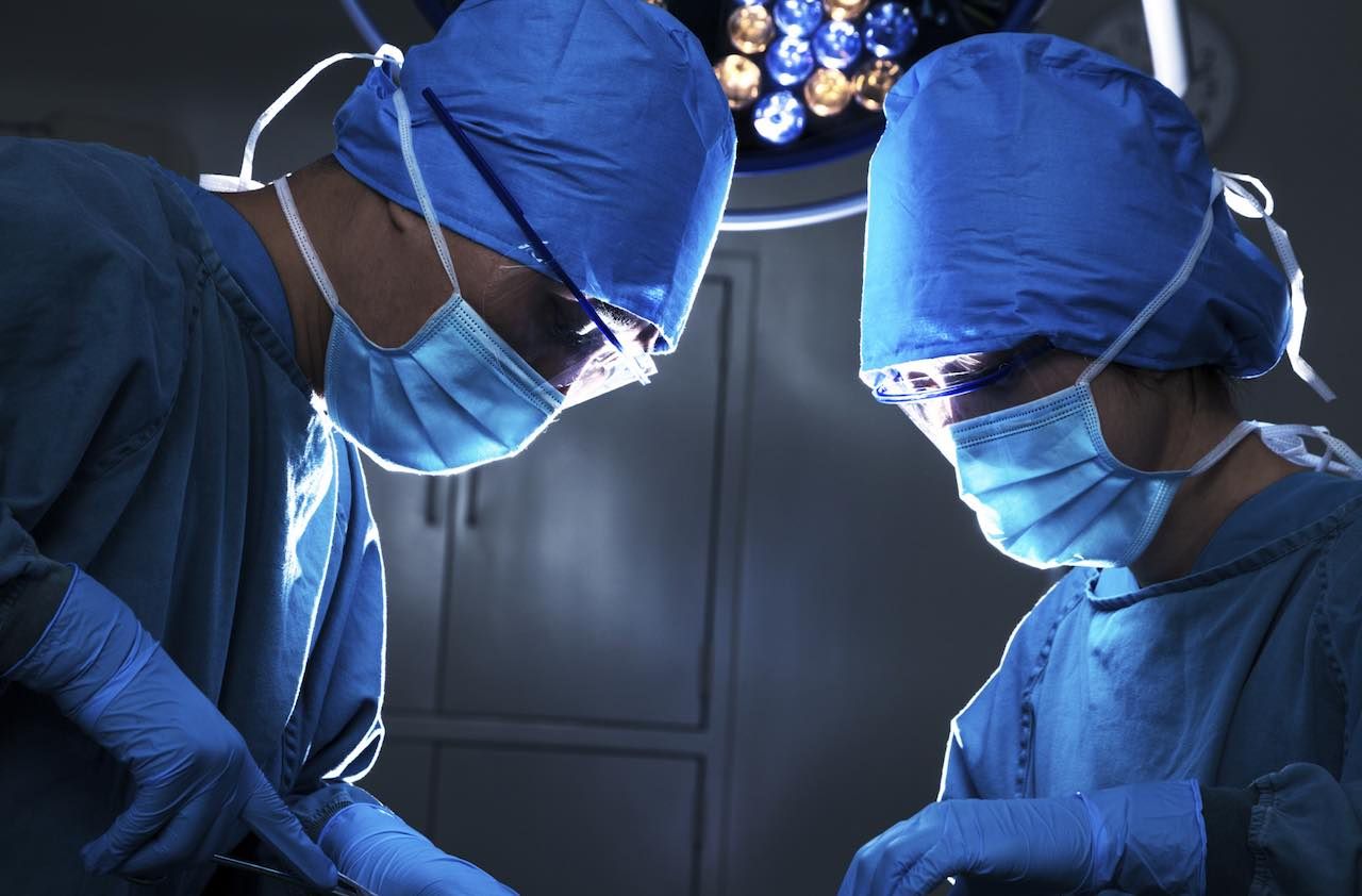 Two surgeons looking down, and concentrating at the operating table