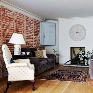 living room with wooden floor and brick wall and and couch