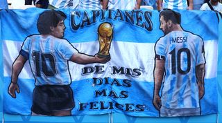 Diego Maradona and Lionel Messi feature on a banner waved by Argentina fans at the 2022 World Cup.