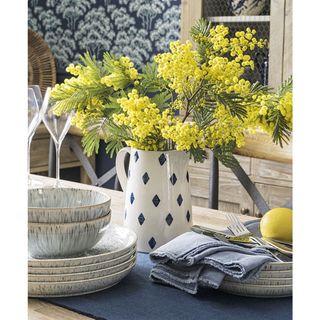 vase with yellow flower on dining table