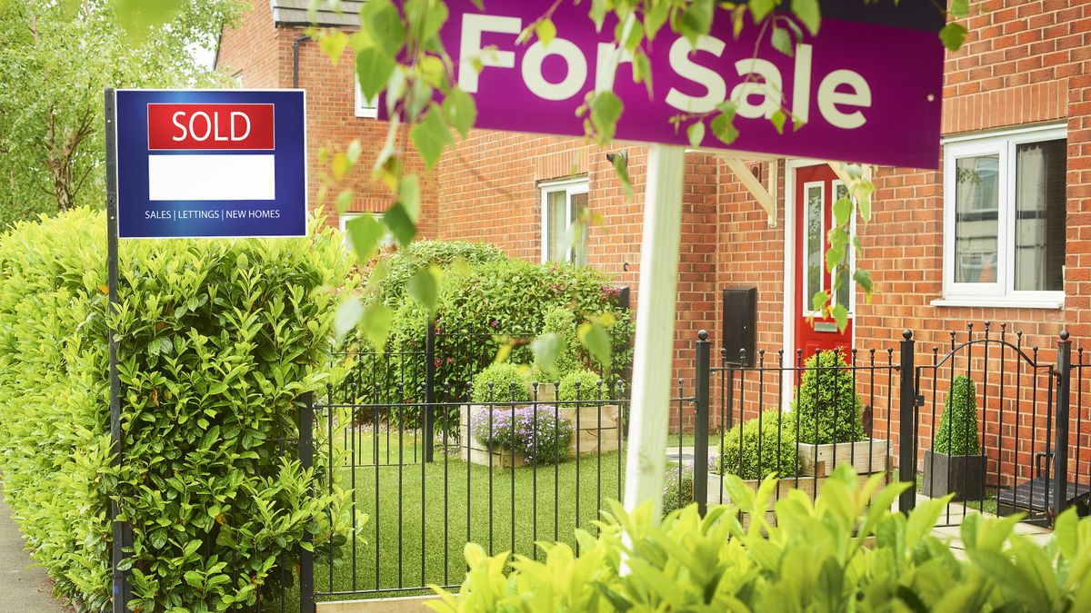 Terraced homes with front gardens, railings and hedges and sold and for sale sign