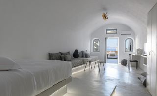 Guestroom with white walls & balcony over looking the sea