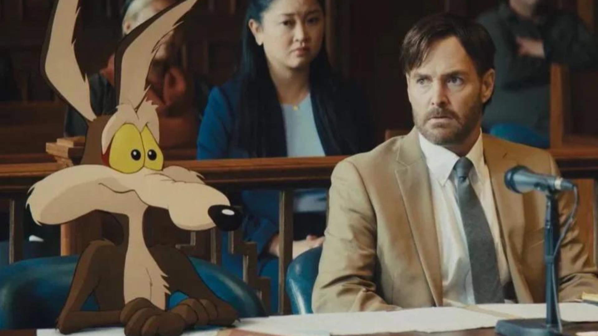 Wild E. Coyote sitting in a courtroom alongside his human lawyer in Coyote Vs Acme