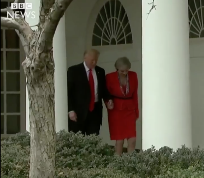 President Trump and Prime Minister Theresa May hold hands. 