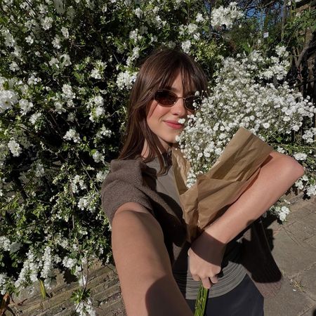 Daisy Edgar-Jones taking a selfie holding flowers 