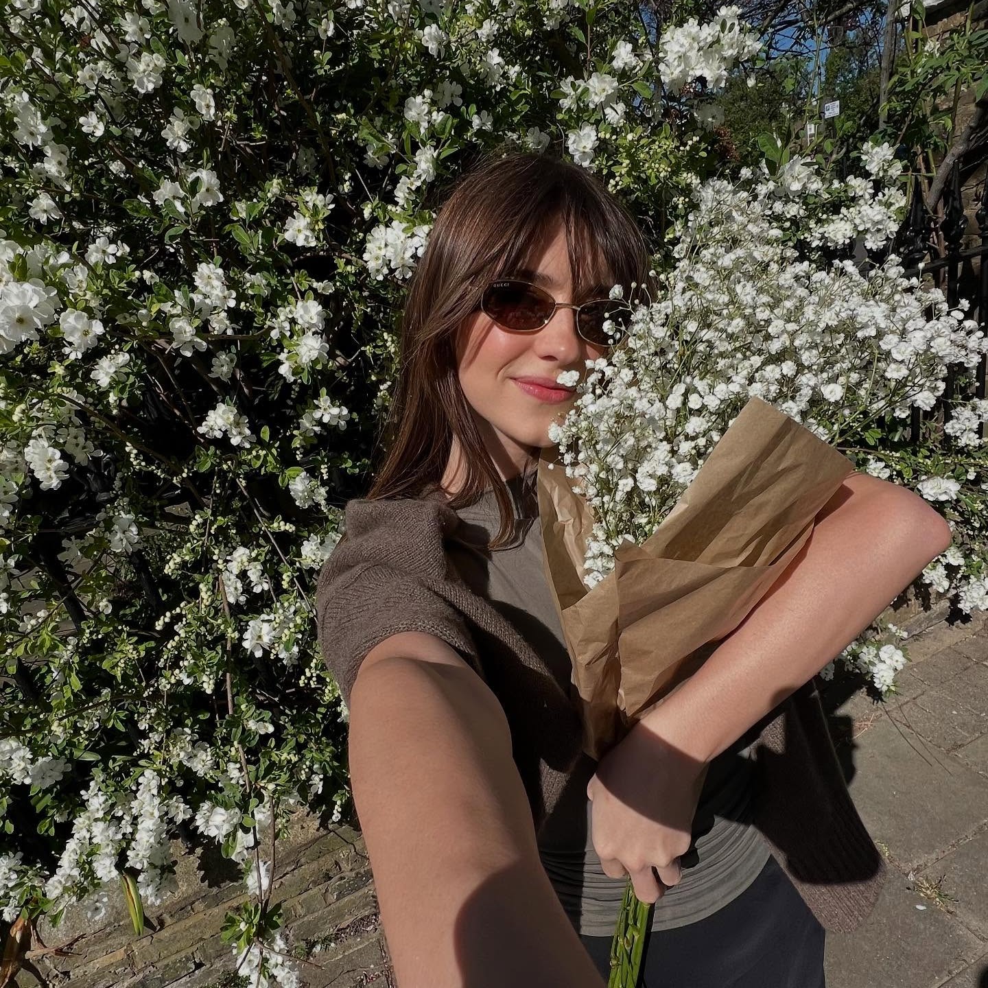 Daisy Edgar-Jones taking a selfie holding flowers 
