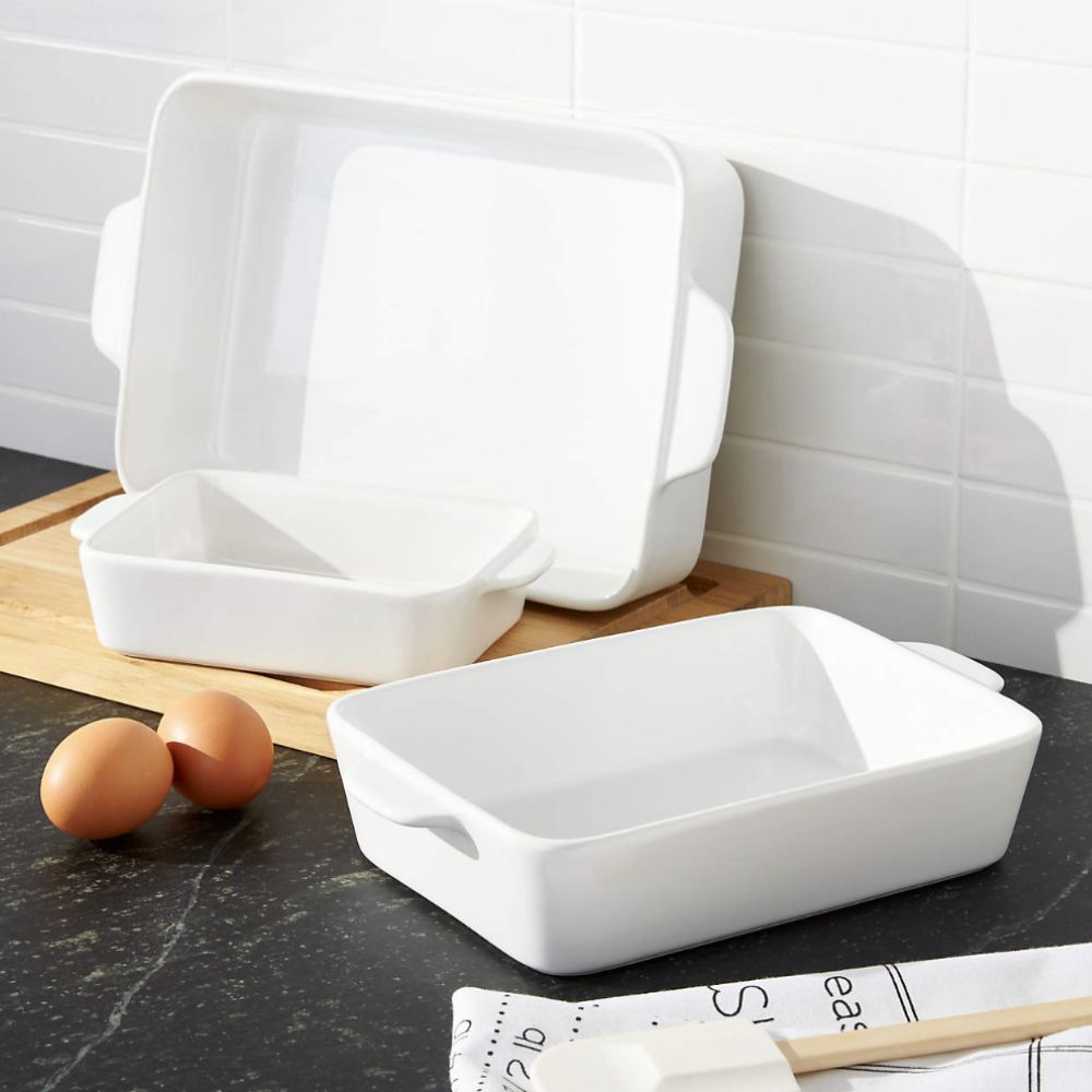Three white baking dishes on a kitchen surface