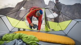 Two men setting up their sleeping bags in their tent