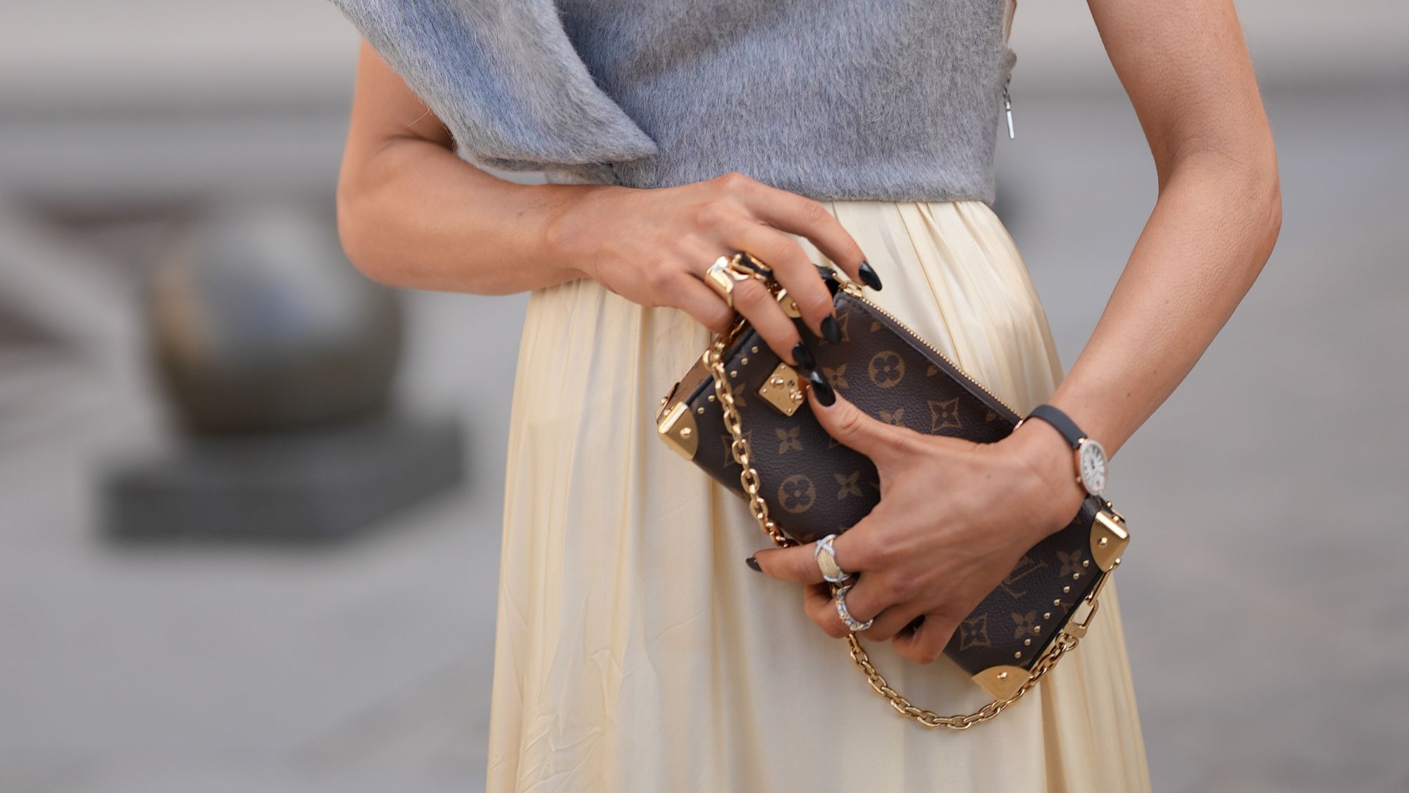 close up of Caro Daur's hands holding a Louis Vuitton handbag
