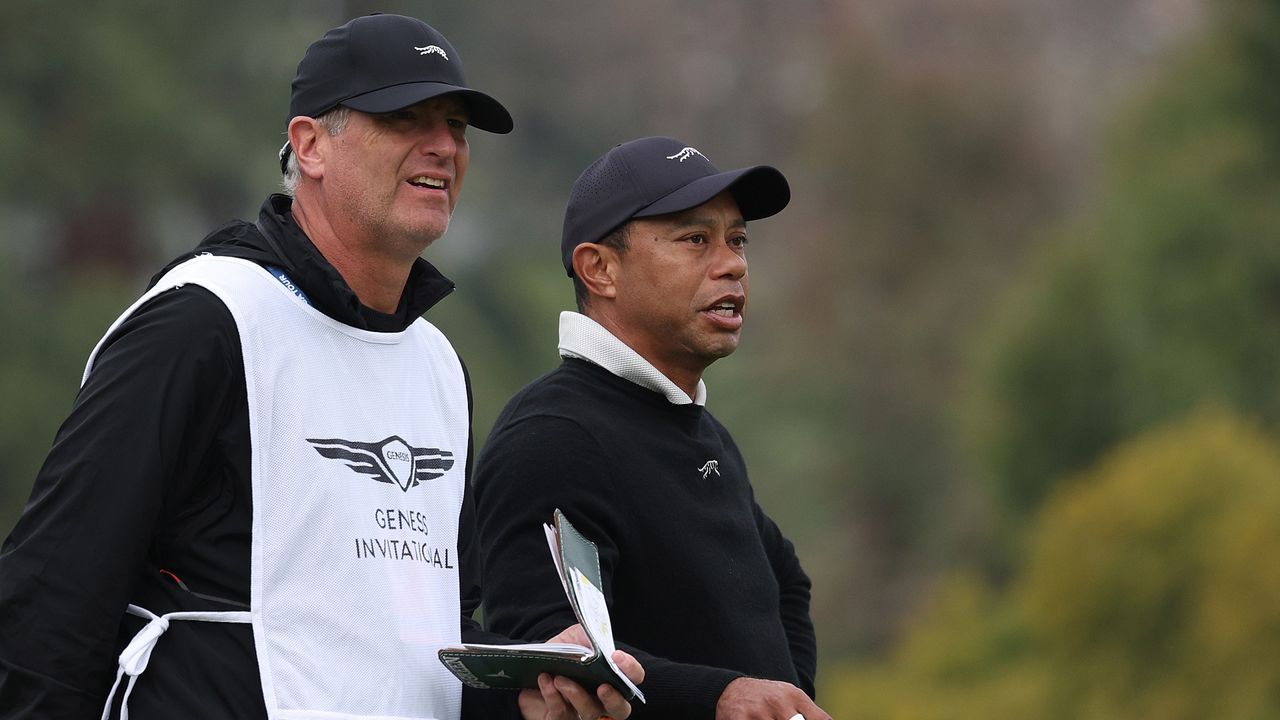 Tiger Woods of the United States converses with his caddie Lance Bennett on the first hole during a pro-am prior to The Genesis Invitational at Riviera Country Club