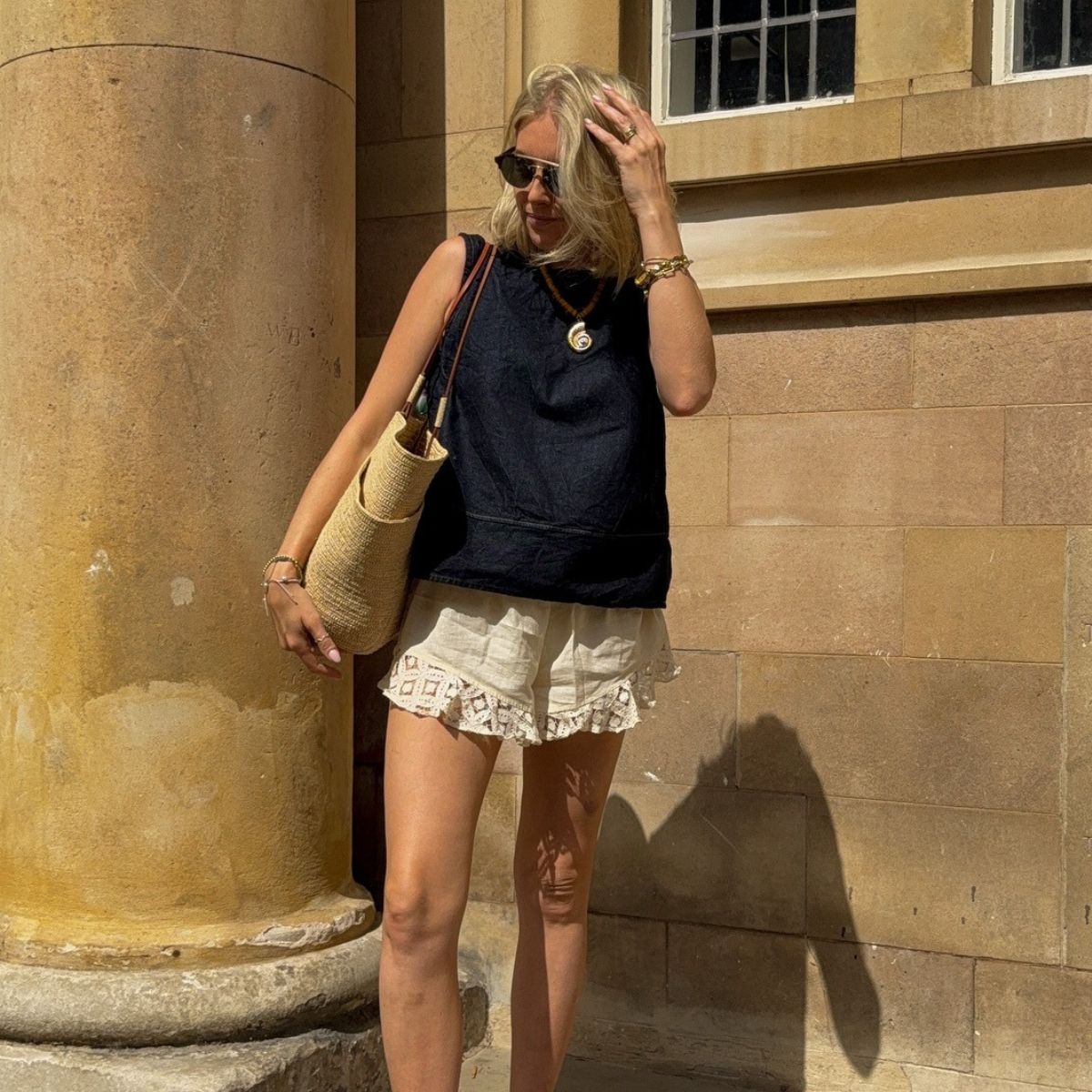 Woman wears linen top, ruffle shorts and basket bag