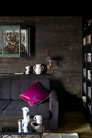 black living room with black sofa and pink cushion
