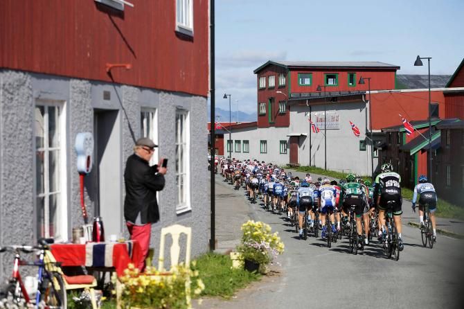 A spectator watches the peloton roll past during stage 2