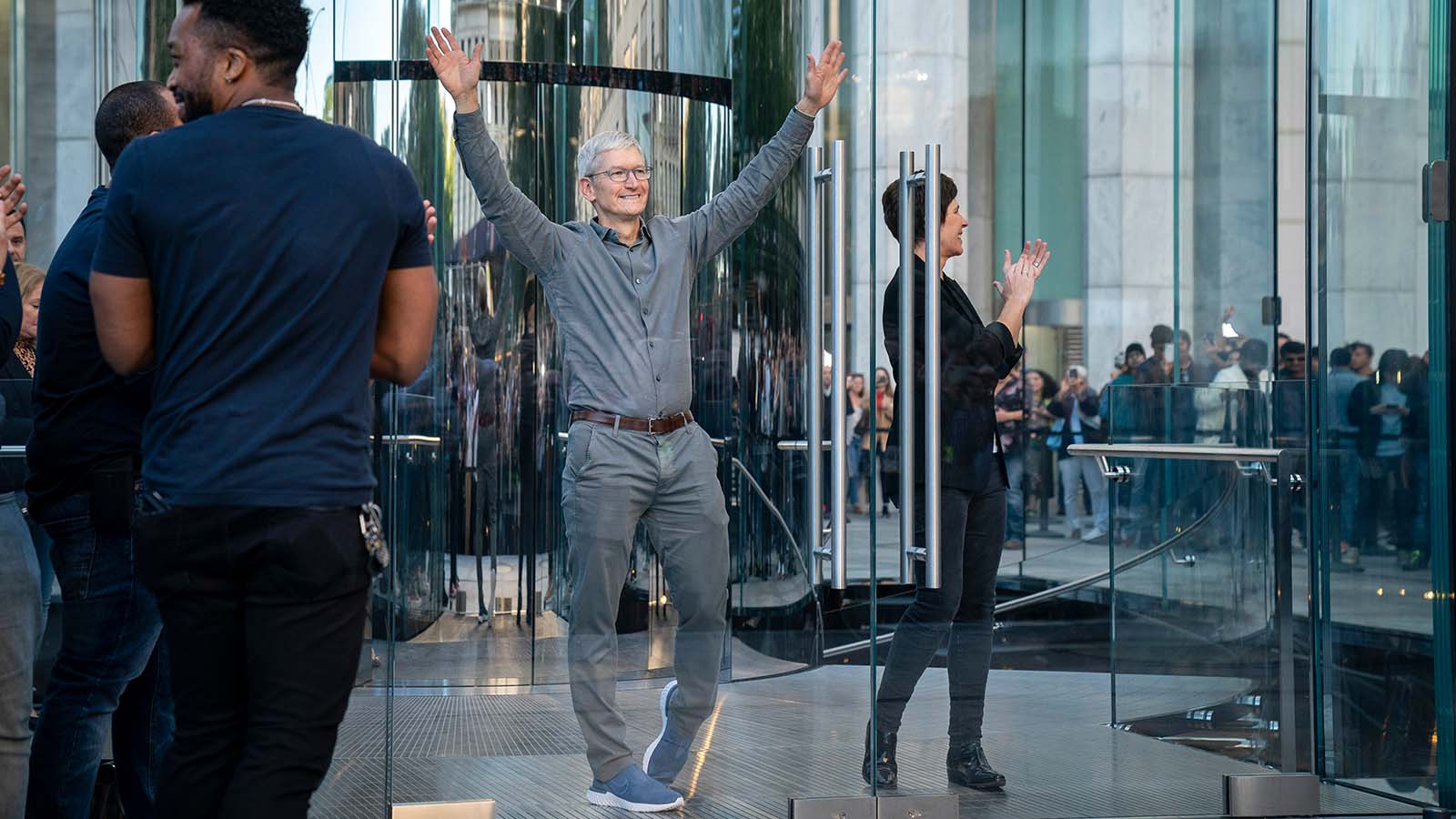 Apple CEO Tim Cook waves to customers before they enter Apple's flagship 5th Avenue store to purchase the new iPhone 11