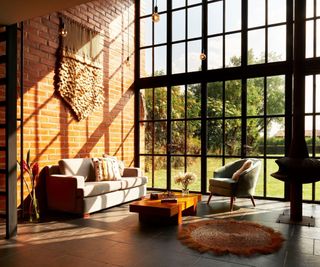 Living room with double height glazing and brick wall