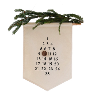 An Advent Christmas countdown made of canvas with a pine branch on top