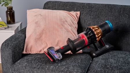 Dyson V16 Piston Animal vacuum with updated Hair screw tool, lifting pet hair from a velvet cushion