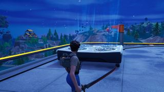 Fortnite - a player stands in front of a large air vent on a roof