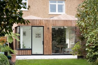 Up Architects Kebony extension of a South London home – with a totally wooden exterior and black crittall doors, leading out onto the garden