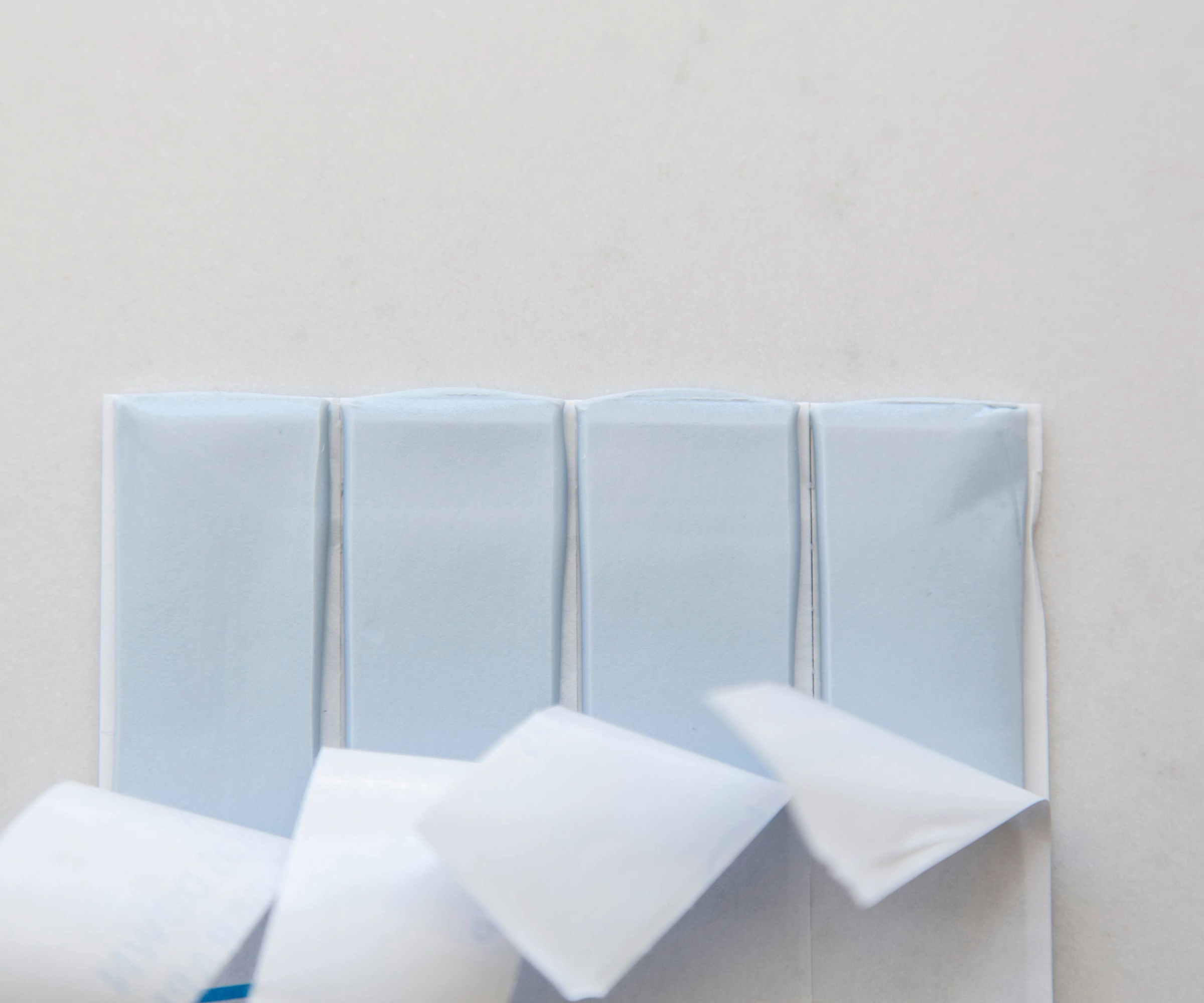 Four strips of Blu Tack peeled back