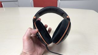 Sennheiser HD 505 headphones held in a man's hand