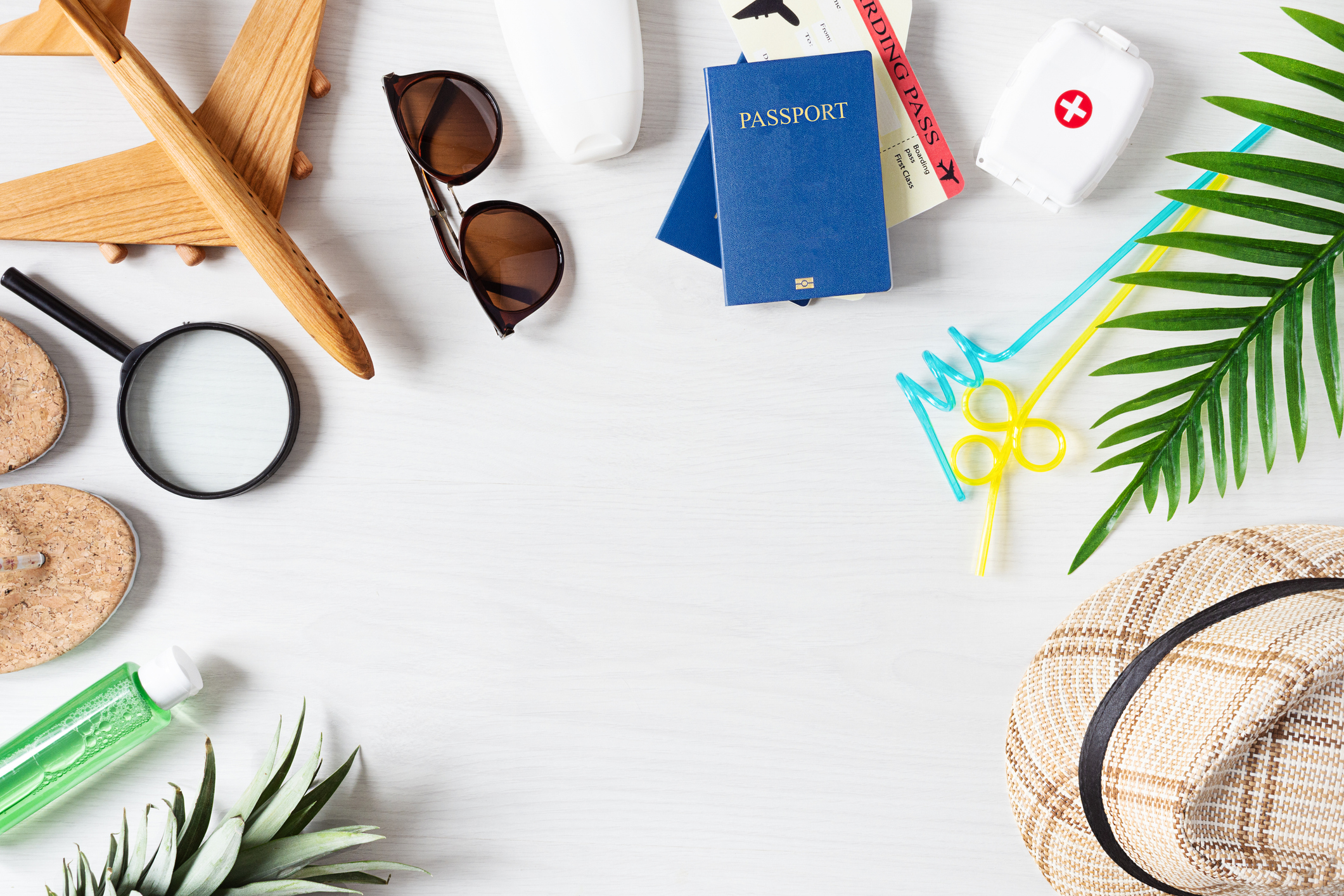 Summer travel essentials, like a first aid kit, sunglasses, passport, footwear, hand sanitizer, and more