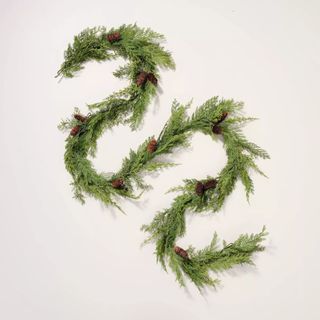 Faux Cedar Drapery Christmas Garland against a gray background. 