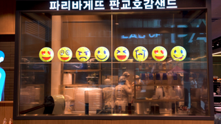 LG transparent OLED with emojis on it, in a bakery