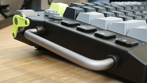 A black and green NuPhy Field75 keyboard on a wooden desk