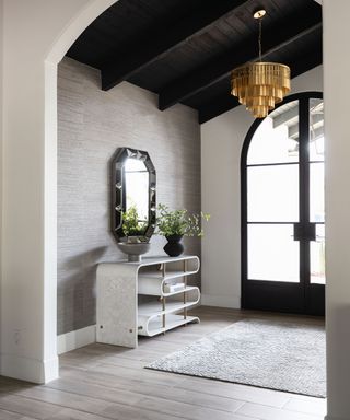 Modern entryway with accent mirror over hallway console and large grey area rug