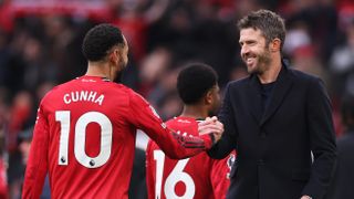 Michael Carrick embraces Matheus Cunha of Manchester United after the team's victory during the Premier League match between Manchester United and Manchester City.