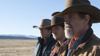 L-R: Tom Pelphrey (Perry Abbott), Lewis Pullman (Rhett Abbott), Josh Brolin (Royal Abbott) stand against barb wire in a desert plain
