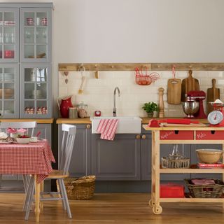 rustic kitchen with red accents and wooden trolley