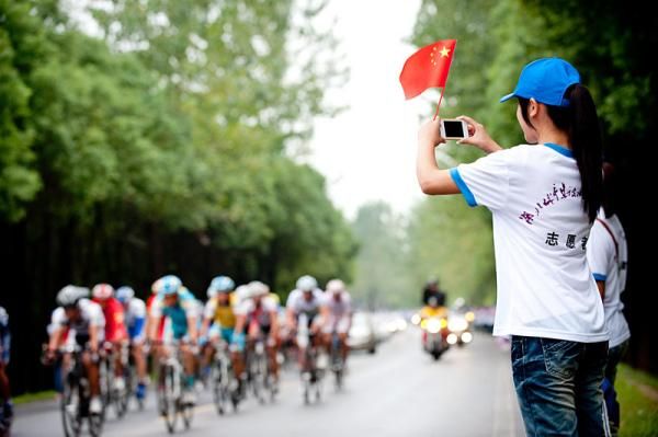 A cycling fan records the passing peloton.