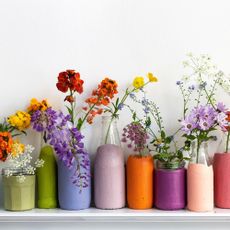 colourfully painted glass milk bottles filled with flowers