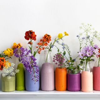 colourfully painted glass milk bottles filled with flowers