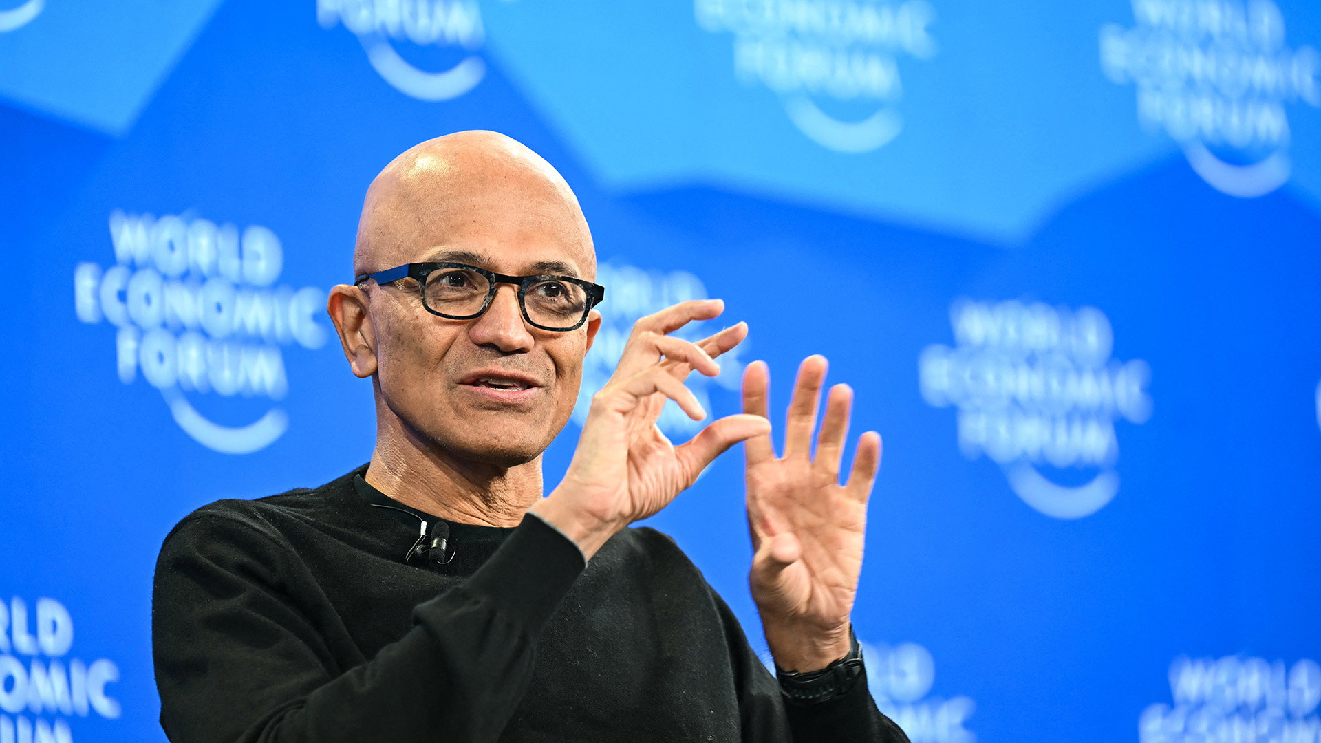 A telephoto shot of Satya Nadella, CEO at Microsoft, speaking onstage at the World Economic Forum 2026 in Davos.