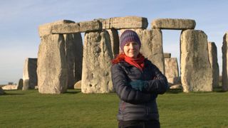 Professor Alice Roberts stands in front of Stonehenge