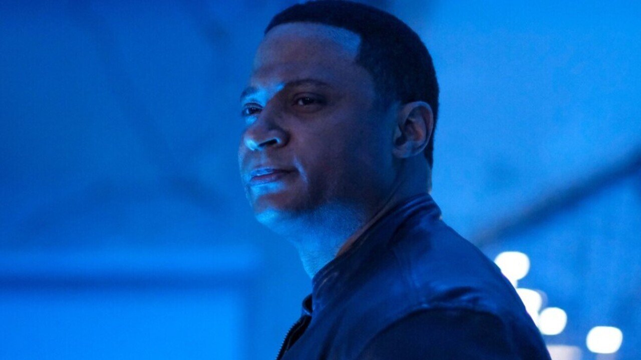 Diggle smiling in a room with blue light Supergirl CW