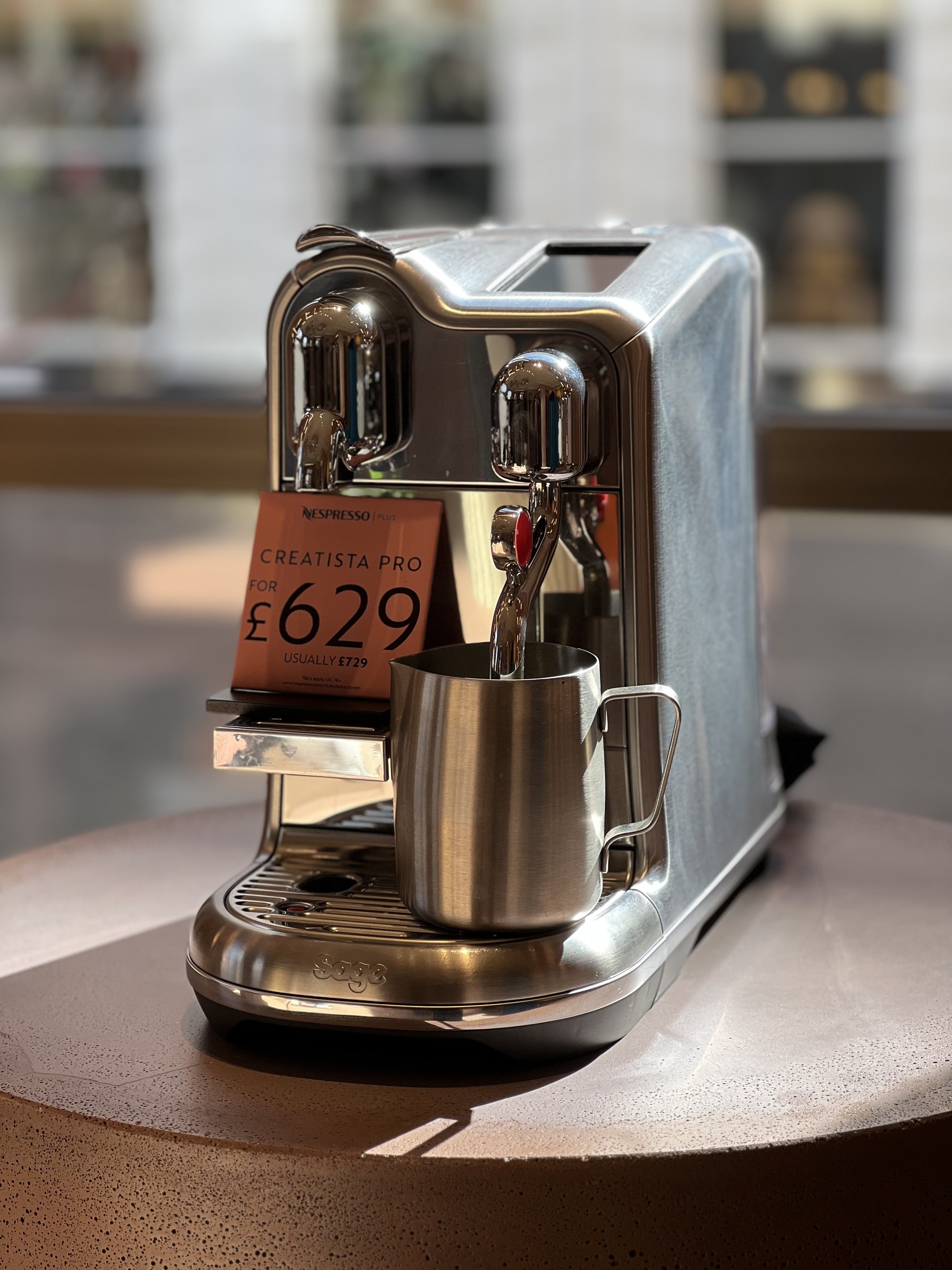 Image of a silver coffee machine in a sunny showroom.