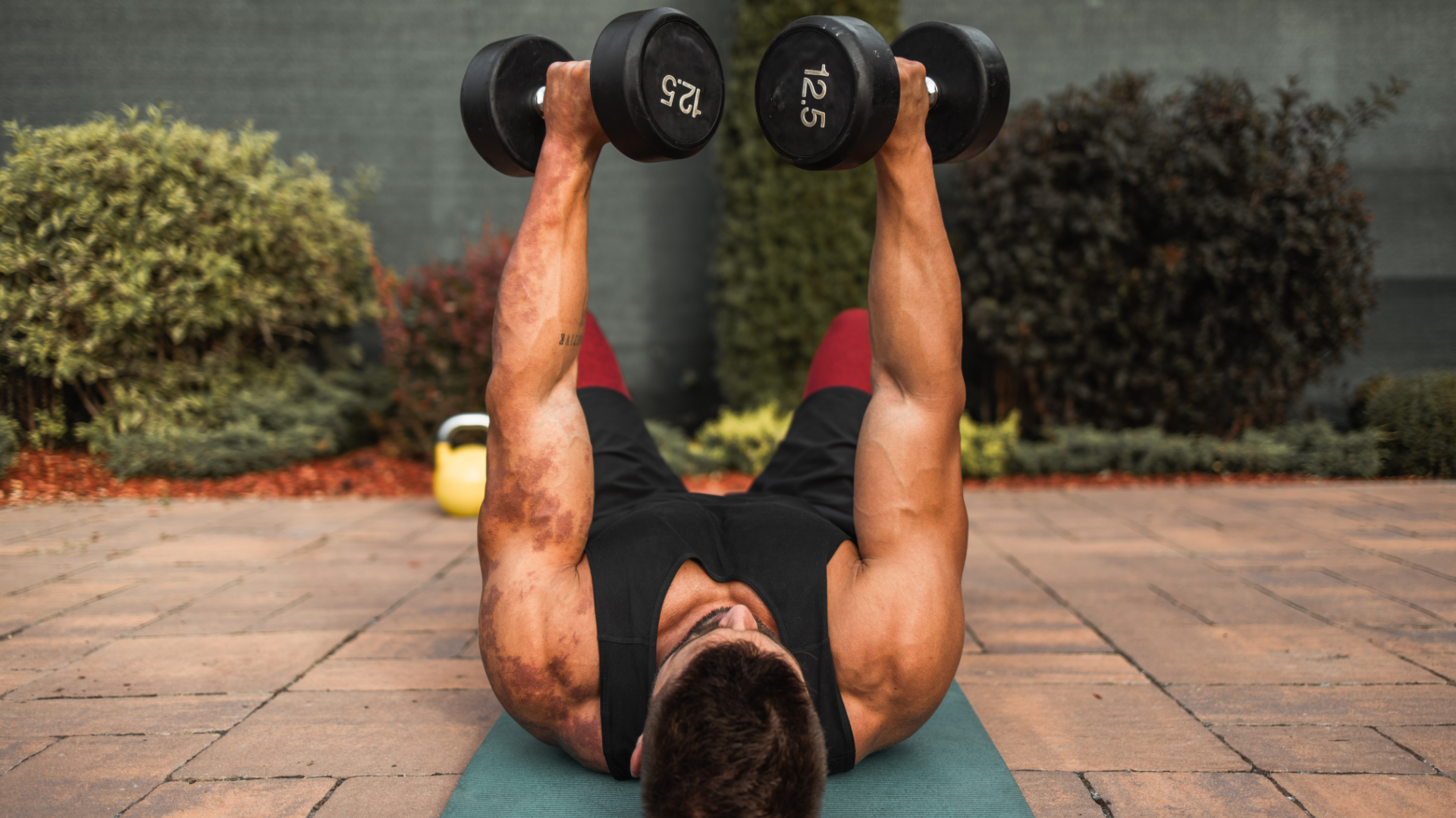 A man performing floor dumbbell press