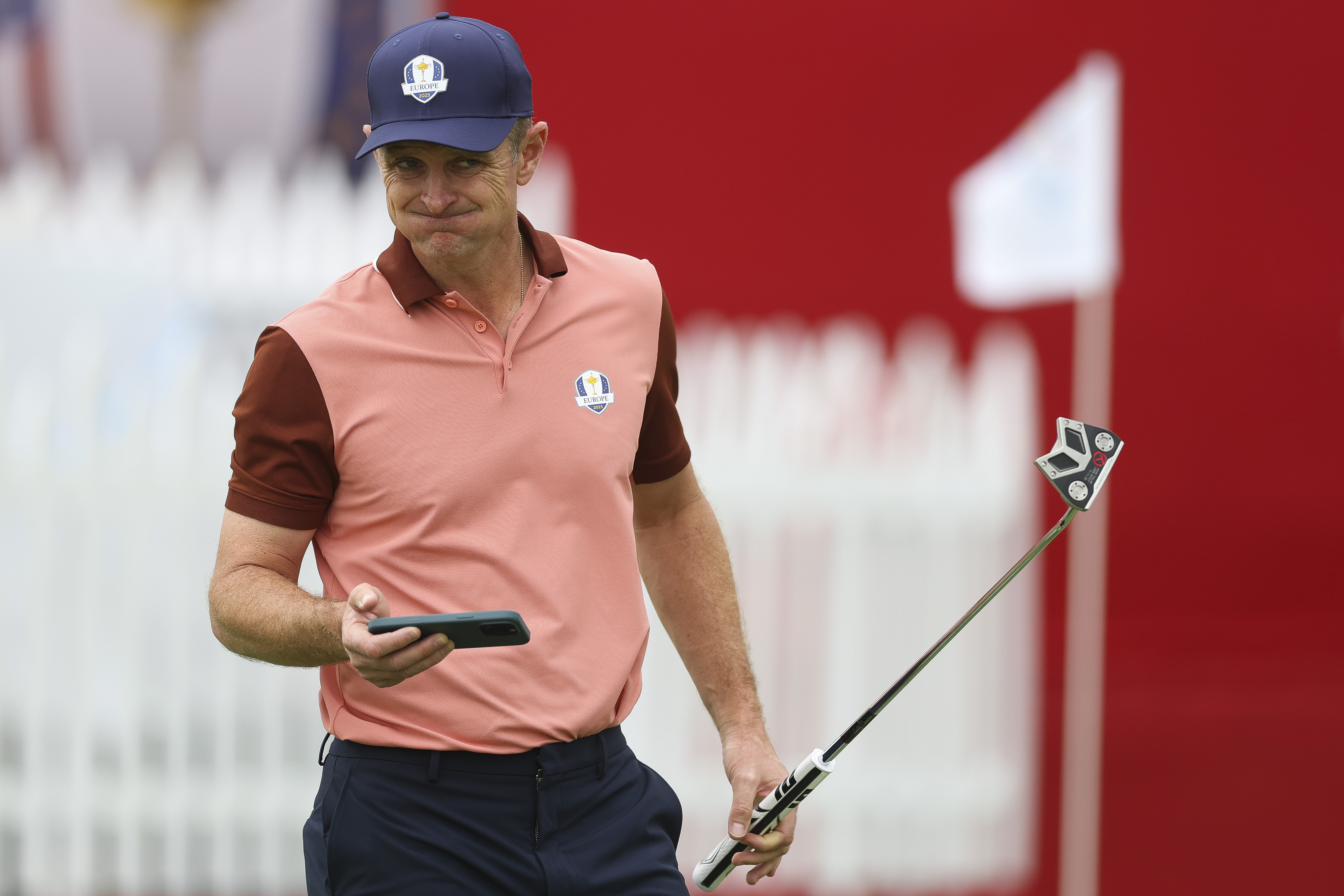 Justin Rose grimaces after looking at his phone