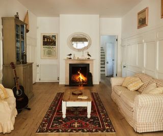 A living room with a fireplace and a guitar in the corner