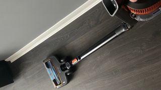 The Shark Anti Hair Wrap Cordless Stick Vacuum Cleaner with PowerFins & Flexology being used with the stick in angled mode